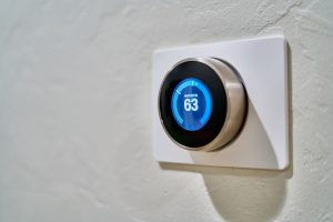 Nest smart thermostat on a wall displaying temperature of 63 degrees, perfect for Home Assistant smart home automation.